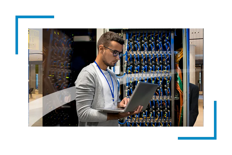 Man in a data center looking at the laptop