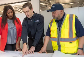 three people looking at a document